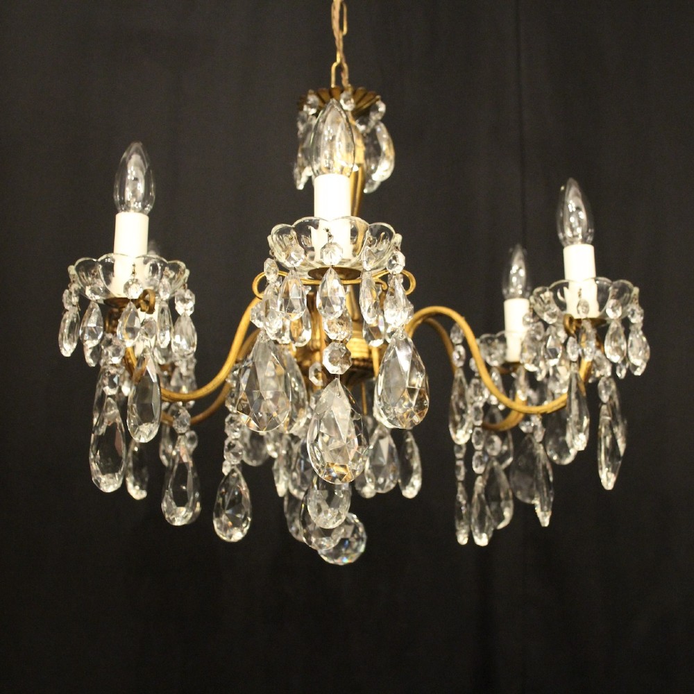 A French gilded brass five-arm chandelier decorated with hanging crystal teardrops and white candle sleeves. View VIII