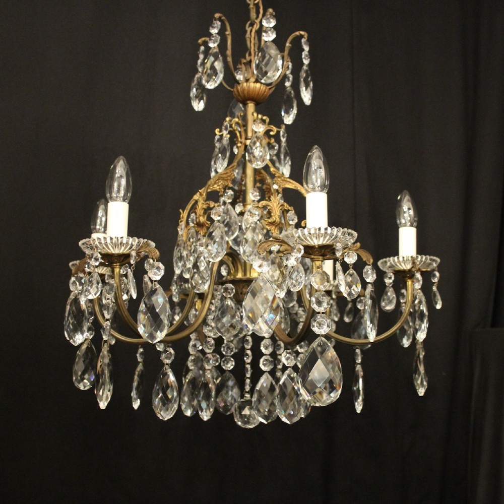 An antique French six-arm crystal chandelier featuring a gilt metal cage frame suspended with faceted glass drops and glass drip pans. View III