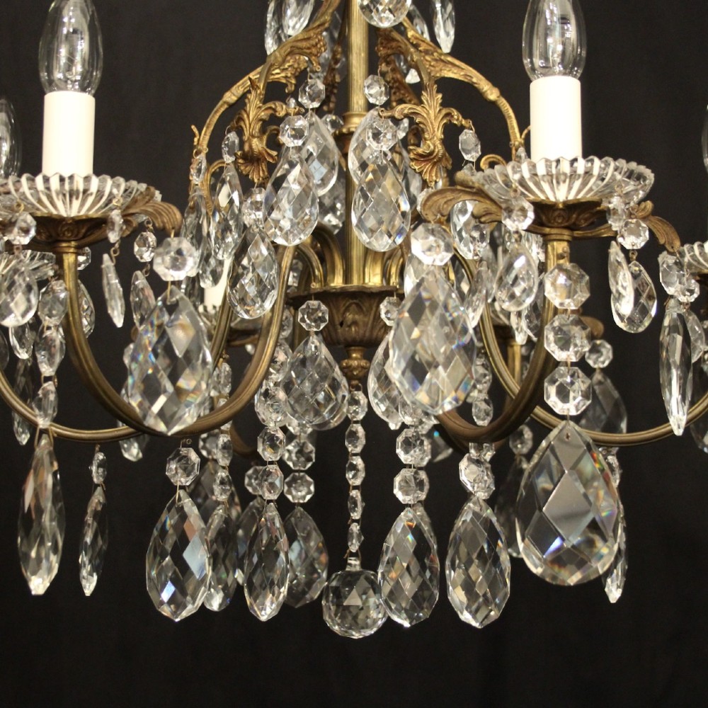 An antique French six-arm crystal chandelier featuring a gilt metal cage frame suspended with faceted glass drops and glass drip pans. View IV