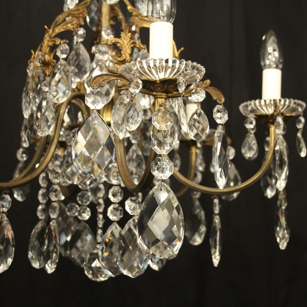 An antique French six-arm crystal chandelier featuring a gilt metal cage frame suspended with faceted glass drops and glass drip pans. View V