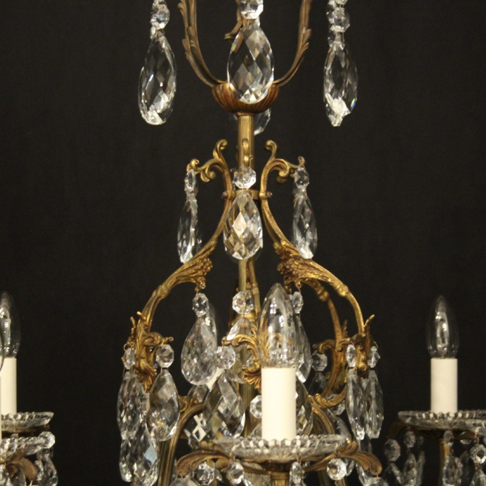 An antique French six-arm crystal chandelier featuring a gilt metal cage frame suspended with faceted glass drops and glass drip pans. View VII