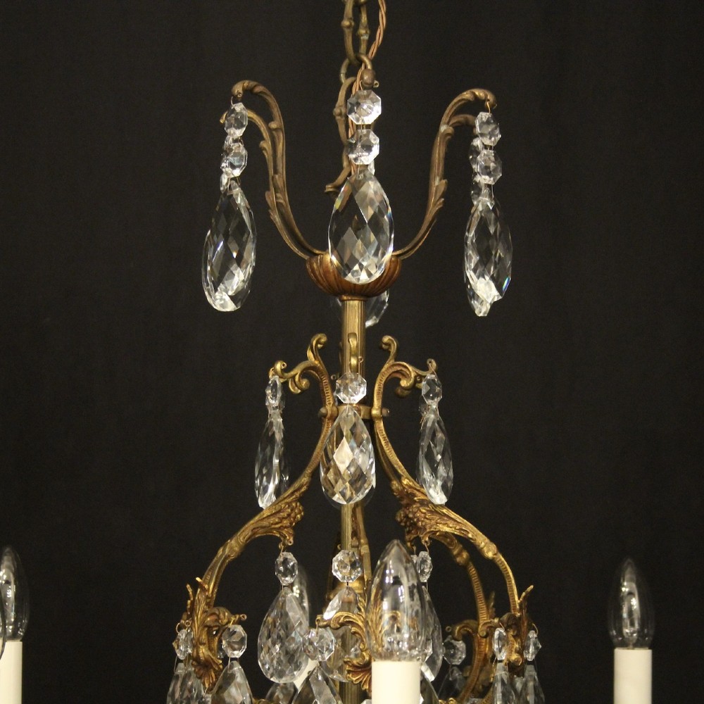 An antique French six-arm crystal chandelier featuring a gilt metal cage frame suspended with faceted glass drops and glass drip pans. View VIII