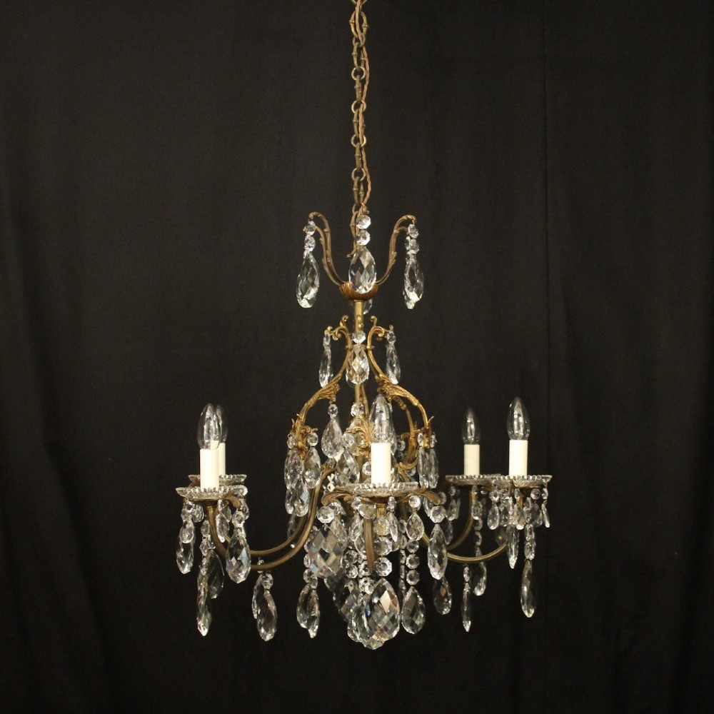 An antique French six-arm crystal chandelier featuring a gilt metal cage frame suspended with faceted glass drops and glass drip pans. View IX