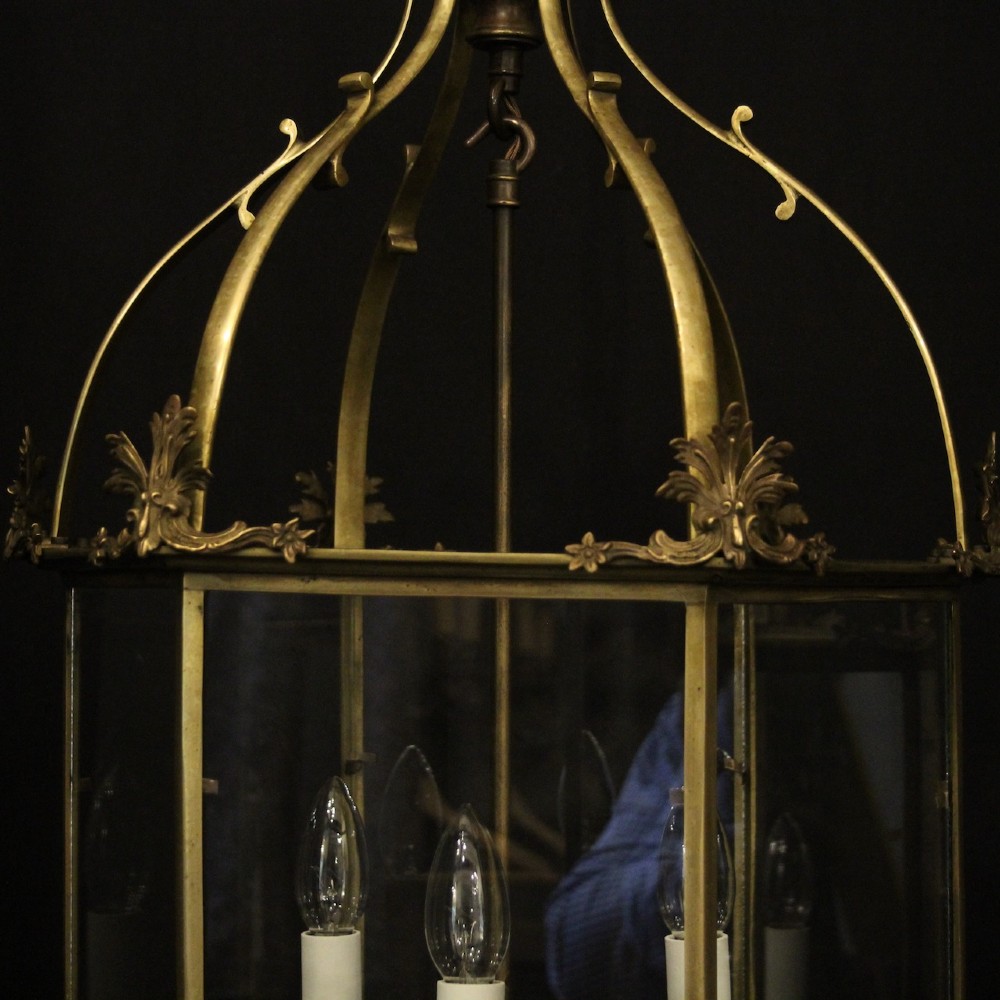 A pair of antique brass hexagonal hall lanterns with glazed glass panels and triple candle-style light fittings suspended from chains. View VI