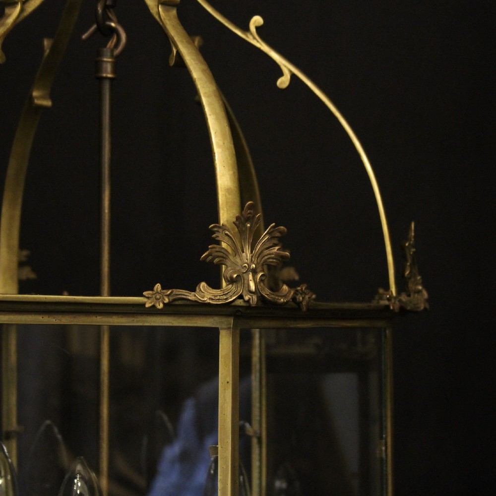 A pair of antique brass hexagonal hall lanterns with glazed glass panels and triple candle-style light fittings suspended from chains. View VII