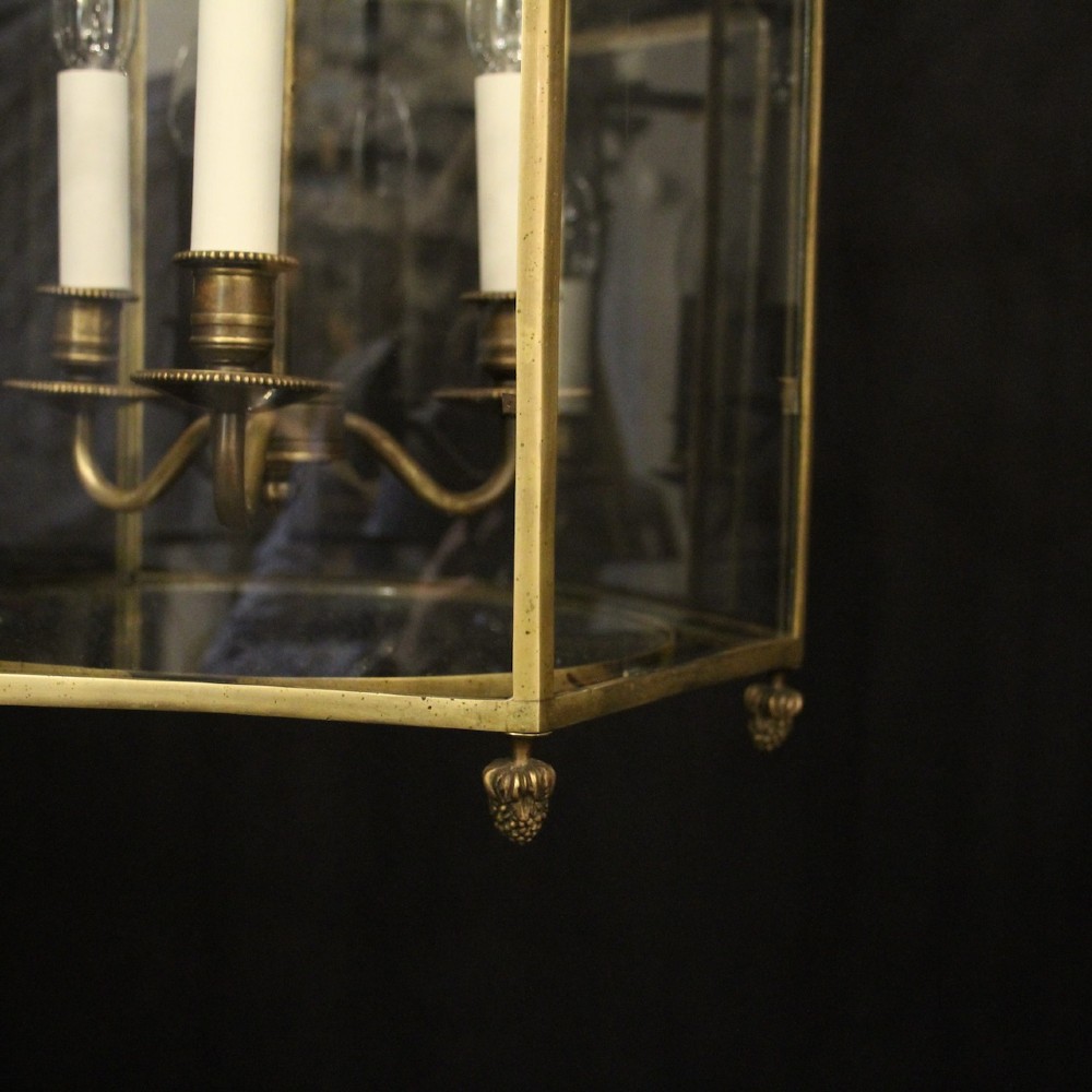 A pair of antique brass hexagonal hall lanterns with glazed glass panels and triple candle-style light fittings suspended from chains. View IX