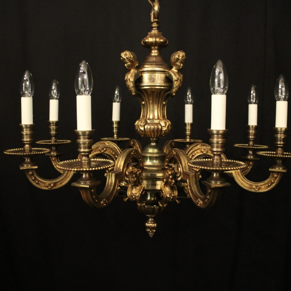 An antique French eight-light chandelier crafted from gilded bronze, featuring sculpted figures, classical motifs, and candle-style bulb holders. View II