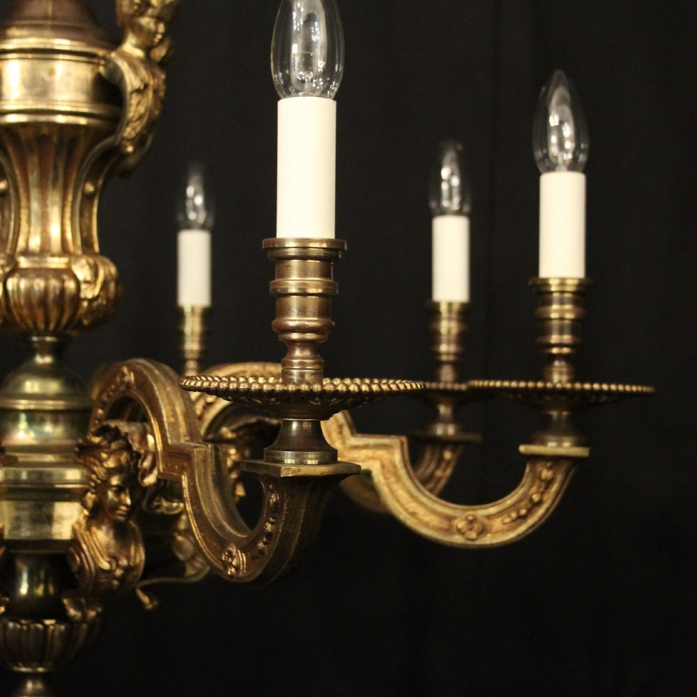 An antique French eight-light chandelier crafted from gilded bronze, featuring sculpted figures, classical motifs, and candle-style bulb holders. View III