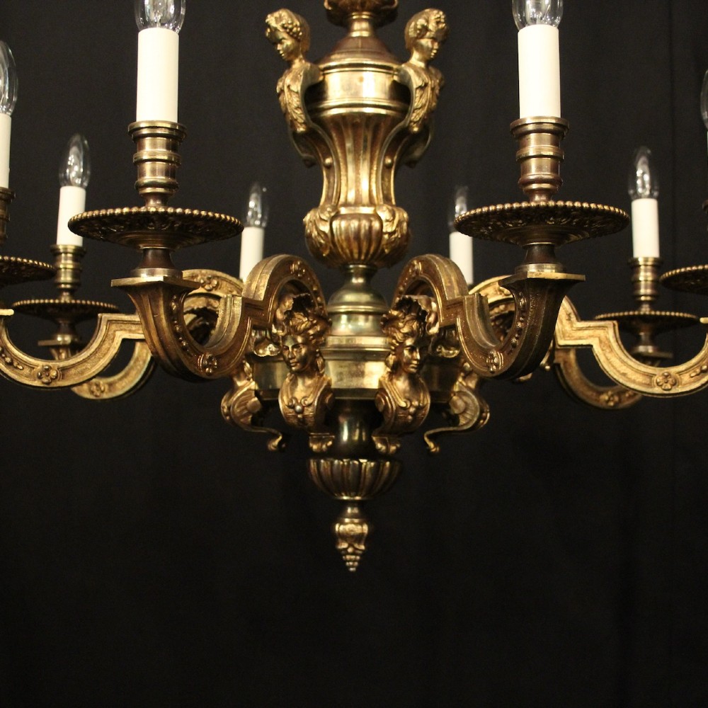 An antique French eight-light chandelier crafted from gilded bronze, featuring sculpted figures, classical motifs, and candle-style bulb holders. View IV