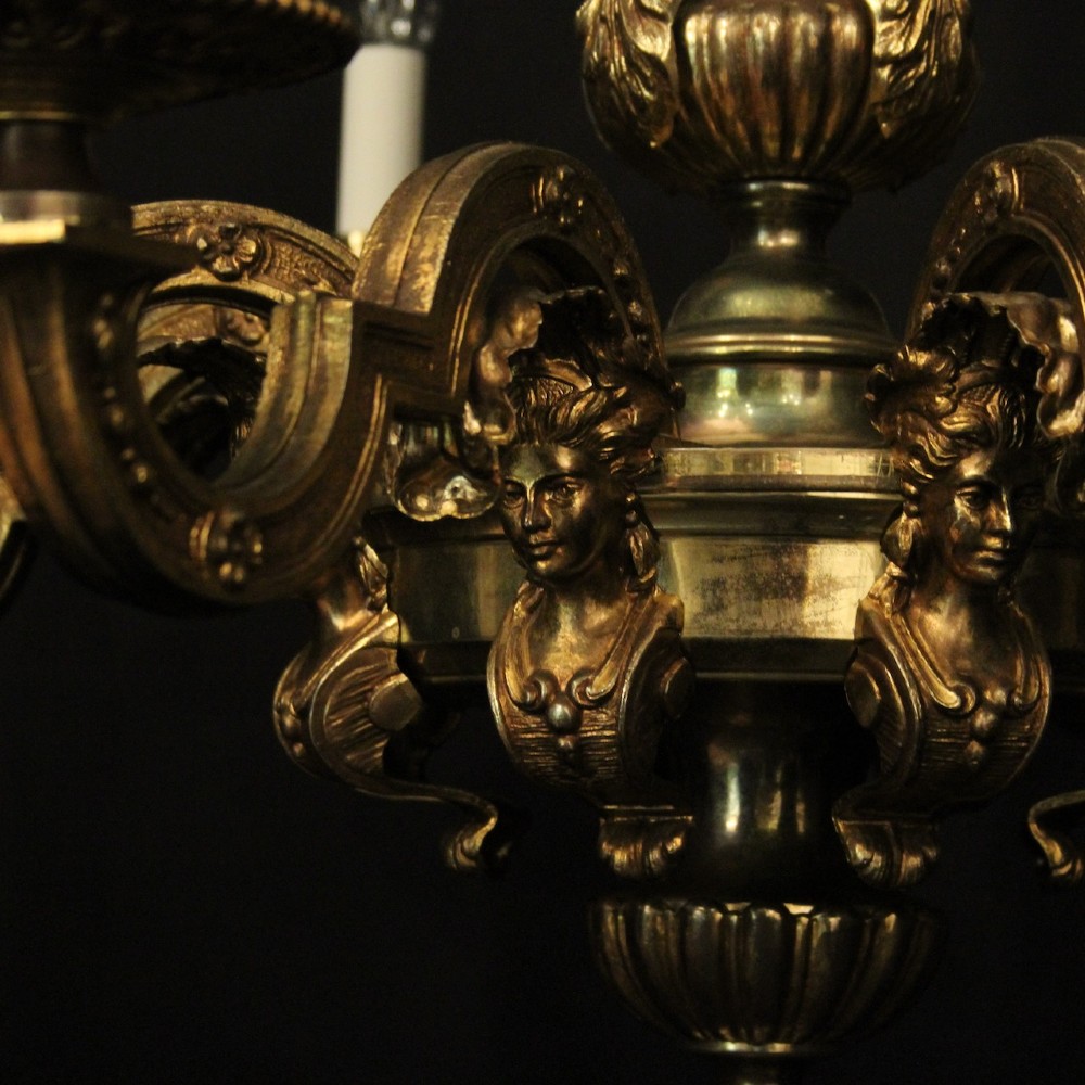 An antique French eight-light chandelier crafted from gilded bronze, featuring sculpted figures, classical motifs, and candle-style bulb holders. View VI