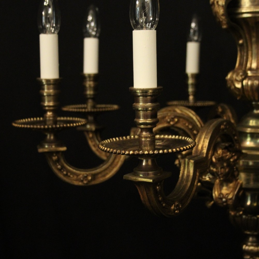 An antique French eight-light chandelier crafted from gilded bronze, featuring sculpted figures, classical motifs, and candle-style bulb holders. View VII