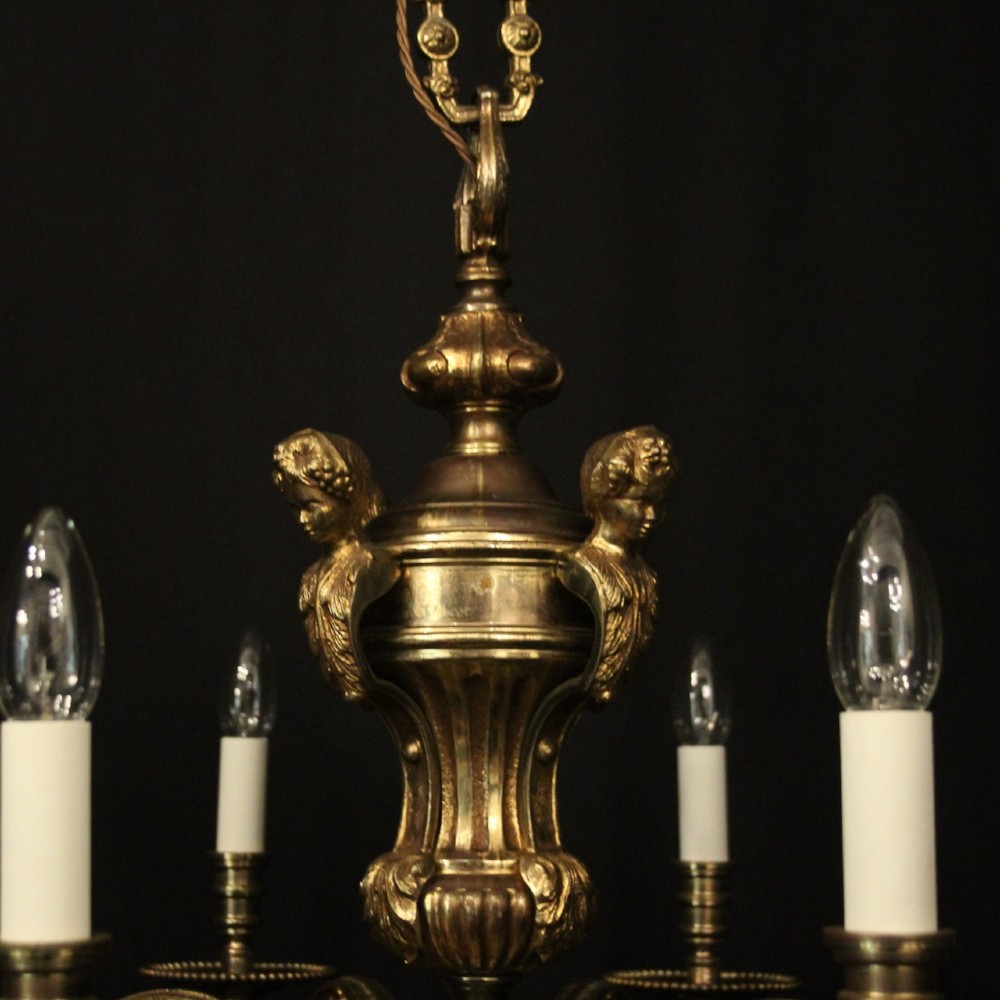 An antique French eight-light chandelier crafted from gilded bronze, featuring sculpted figures, classical motifs, and candle-style bulb holders. View IX