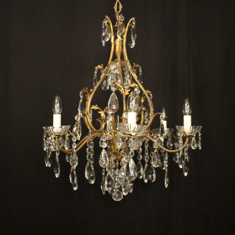 A French gilded metal cage chandelier featuring seven light points decorated with faceted crystal glass drops and candle-style bulb holders.