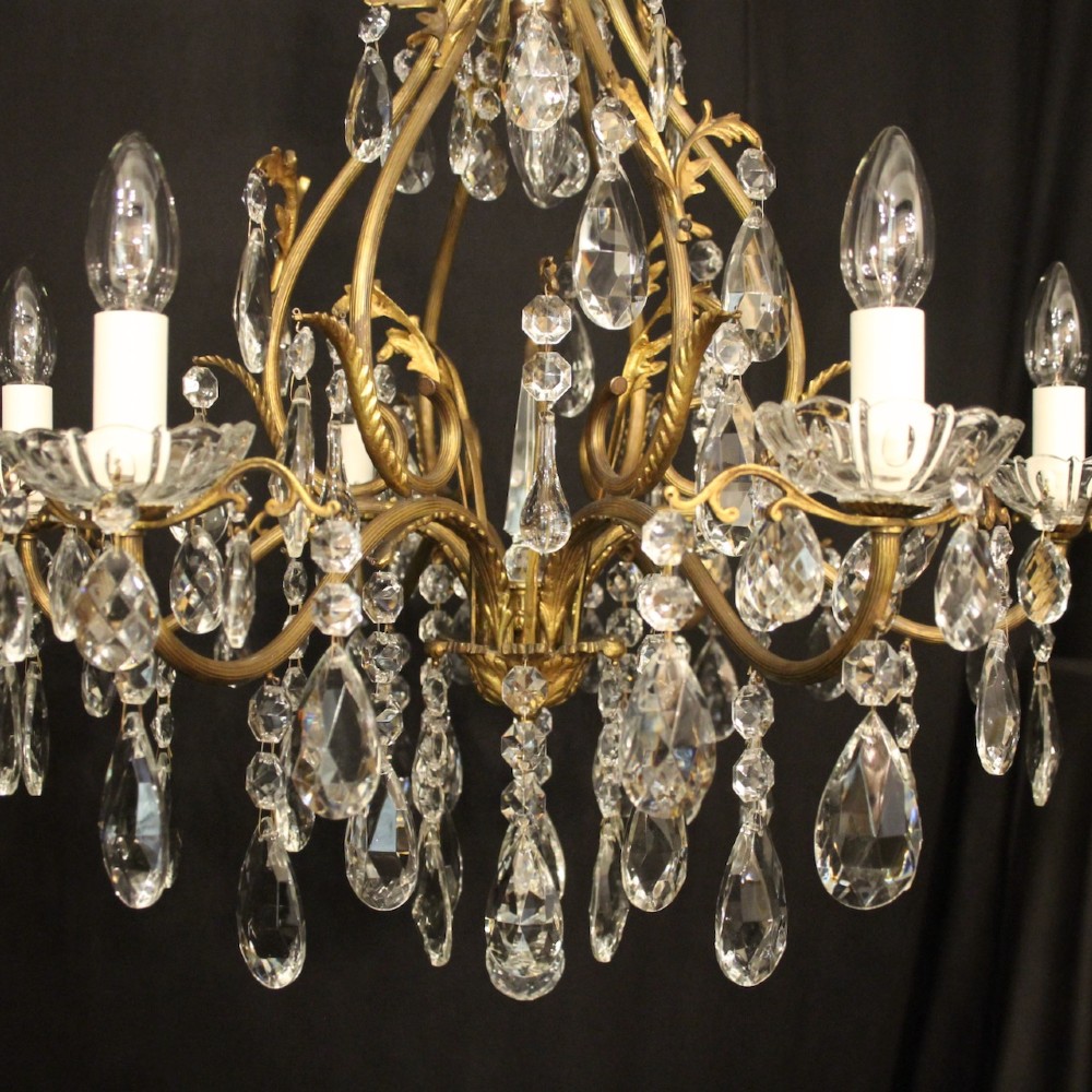 A French gilded metal cage chandelier featuring seven light points decorated with faceted crystal glass drops and candle-style bulb holders. View III