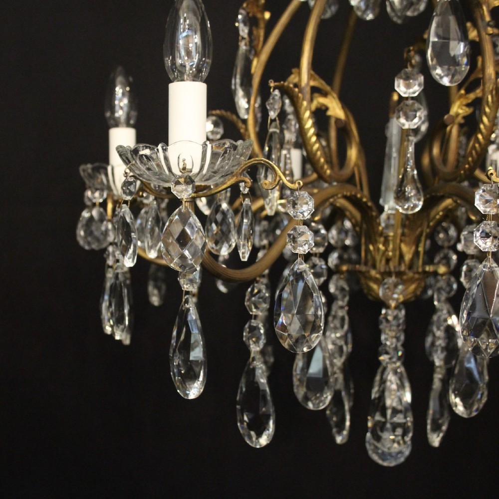 A French gilded metal cage chandelier featuring seven light points decorated with faceted crystal glass drops and candle-style bulb holders. View IV