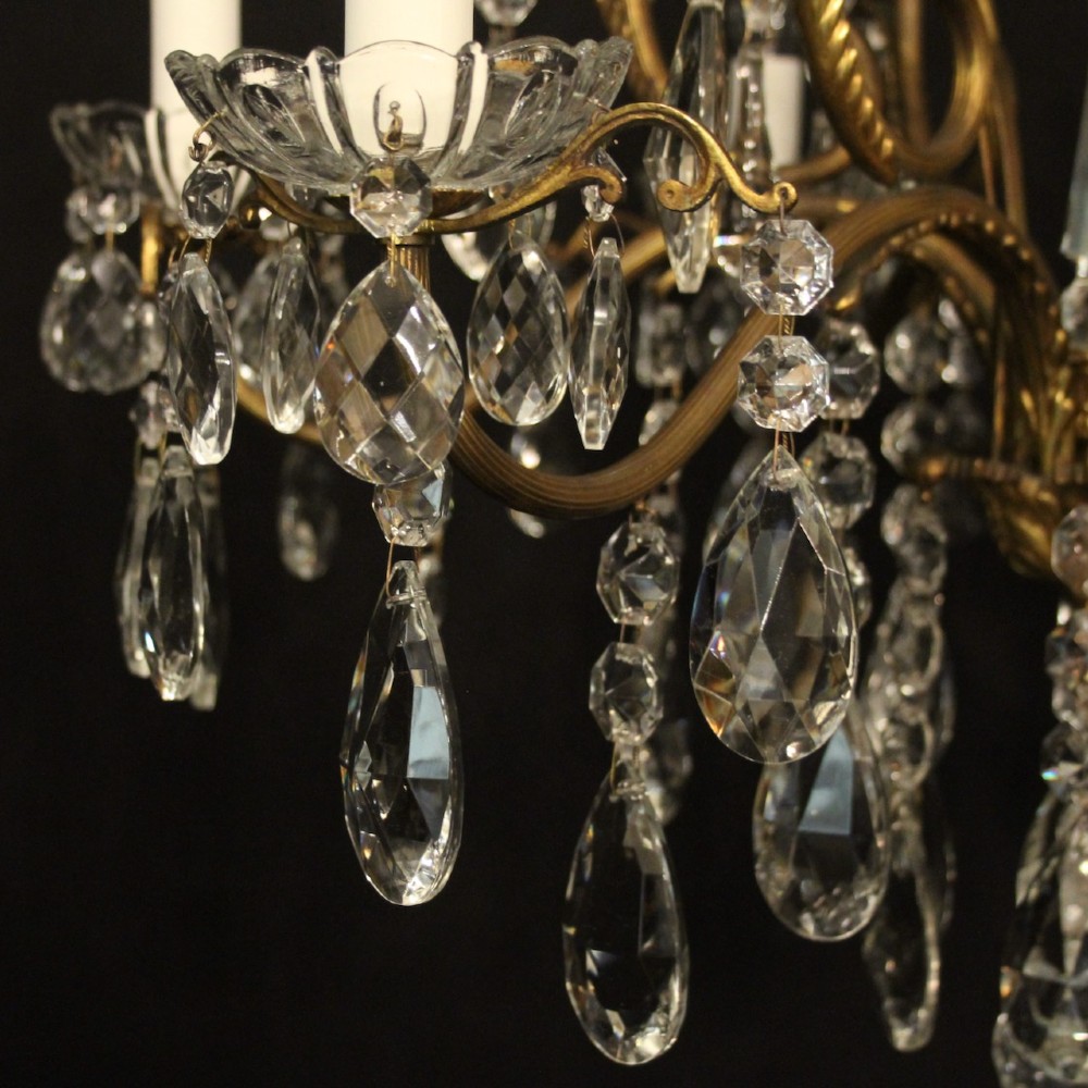 A French gilded metal cage chandelier featuring seven light points decorated with faceted crystal glass drops and candle-style bulb holders. View V