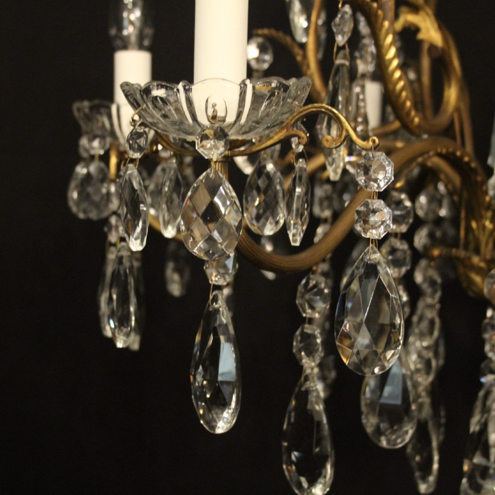 A French gilded metal cage chandelier featuring seven light points decorated with faceted crystal glass drops and candle-style bulb holders. View VI