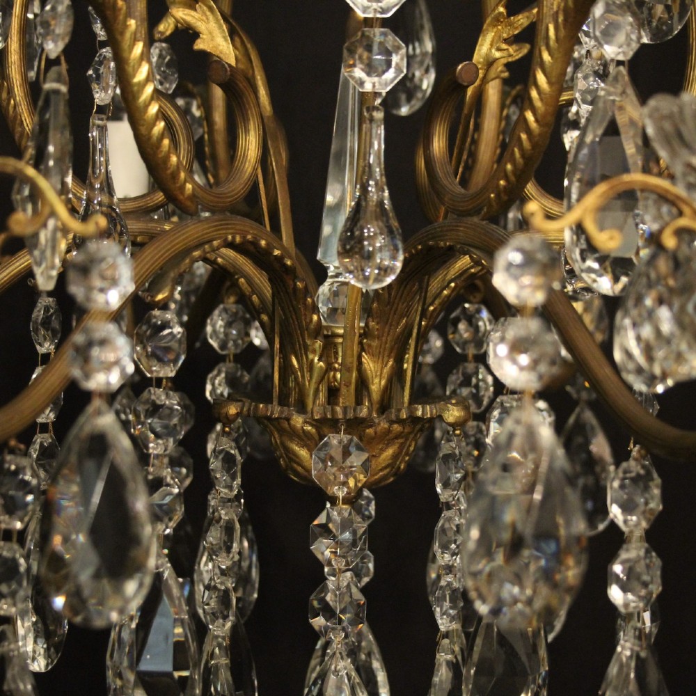 A French gilded metal cage chandelier featuring seven light points decorated with faceted crystal glass drops and candle-style bulb holders. View VII