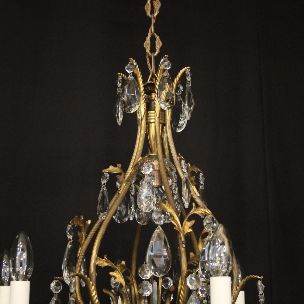 A French gilded metal cage chandelier featuring seven light points decorated with faceted crystal glass drops and candle-style bulb holders. View IX