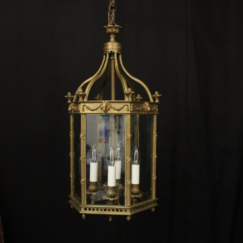 An English nineteenth-century gilded bronze four-light hall lantern with glazed glass panels and classical festoon ornamentation.