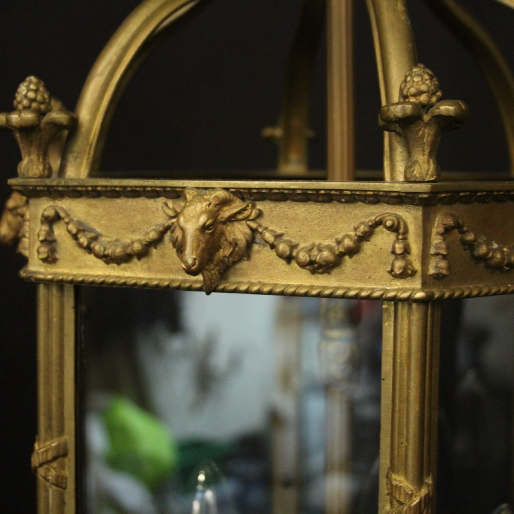An English nineteenth-century gilded bronze four-light hall lantern with glazed glass panels and classical festoon ornamentation. View VI