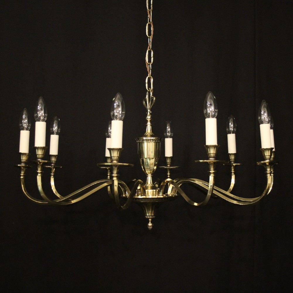 A repolished brass ten-light chandelier featuring sweeping curved arms, candle sleeves, and a central urn-shaped stem hanging from a chain.