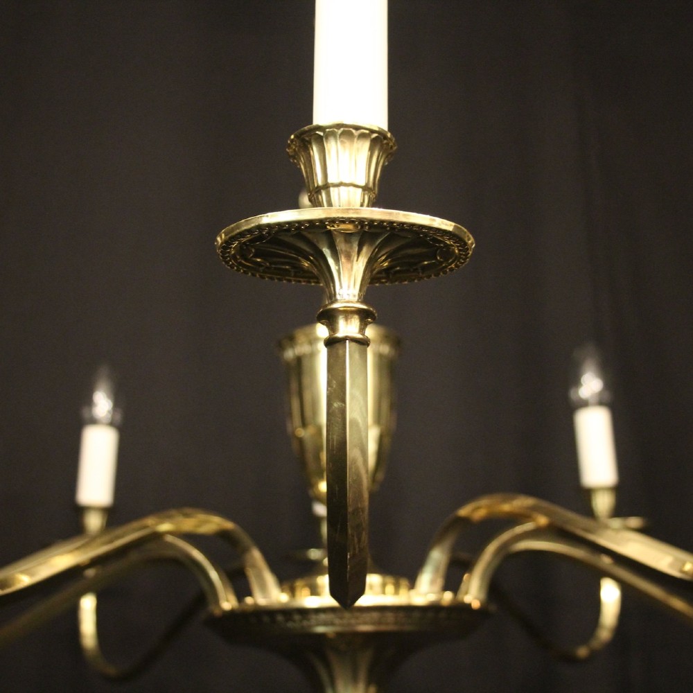 A repolished brass ten-light chandelier featuring sweeping curved arms, candle sleeves, and a central urn-shaped stem hanging from a chain. View IV