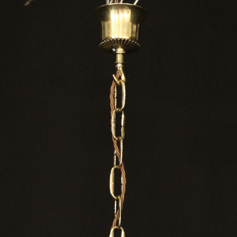 A repolished brass ten-light chandelier featuring sweeping curved arms, candle sleeves, and a central urn-shaped stem hanging from a chain. View X
