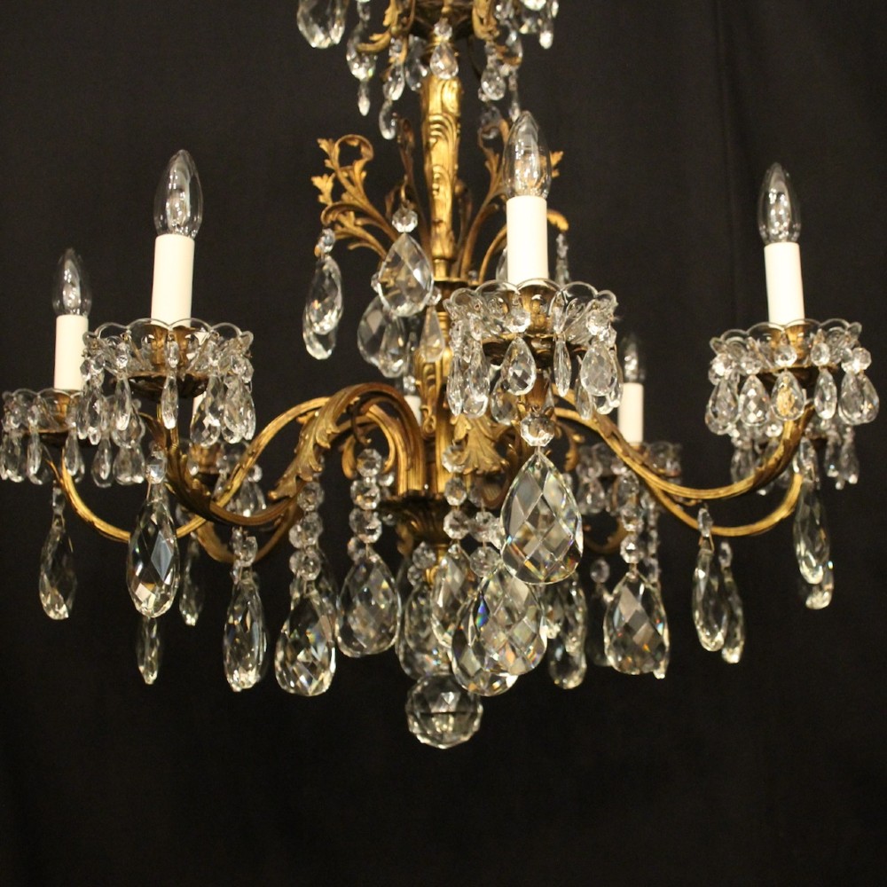 An eight-light French chandelier featuring a gilded metal frame adorned with cut crystal teardrop pendants and glass candle sleeves. View II