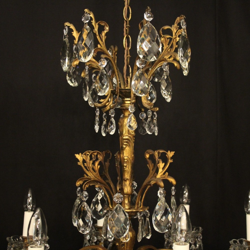 An eight-light French chandelier featuring a gilded metal frame adorned with cut crystal teardrop pendants and glass candle sleeves. View IX