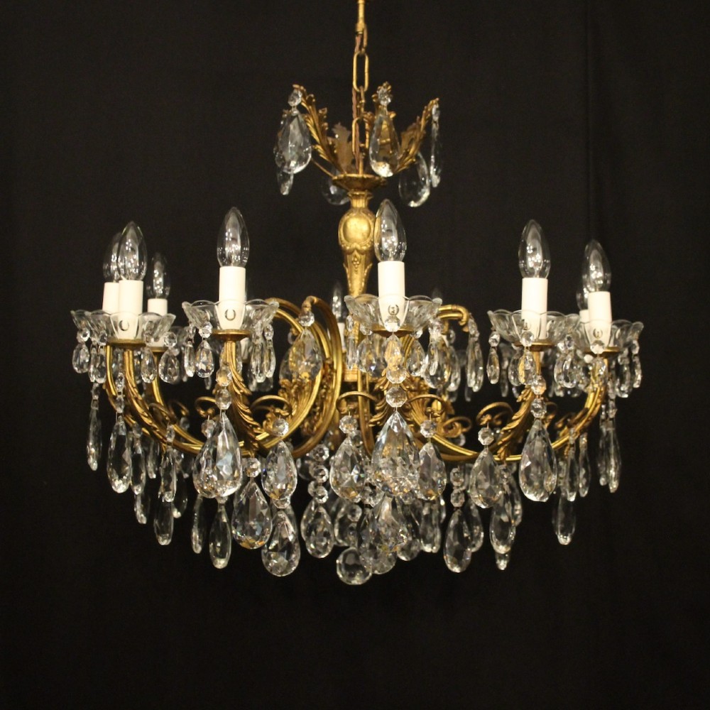 A French gilded brass twelve-light chandelier hung with faceted crystal droplets and glass bobeches.