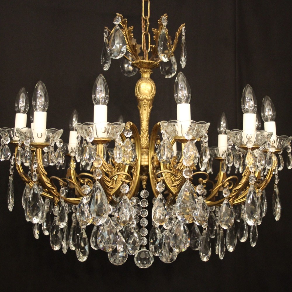 A French gilded brass twelve-light chandelier hung with faceted crystal droplets and glass bobeches. View II