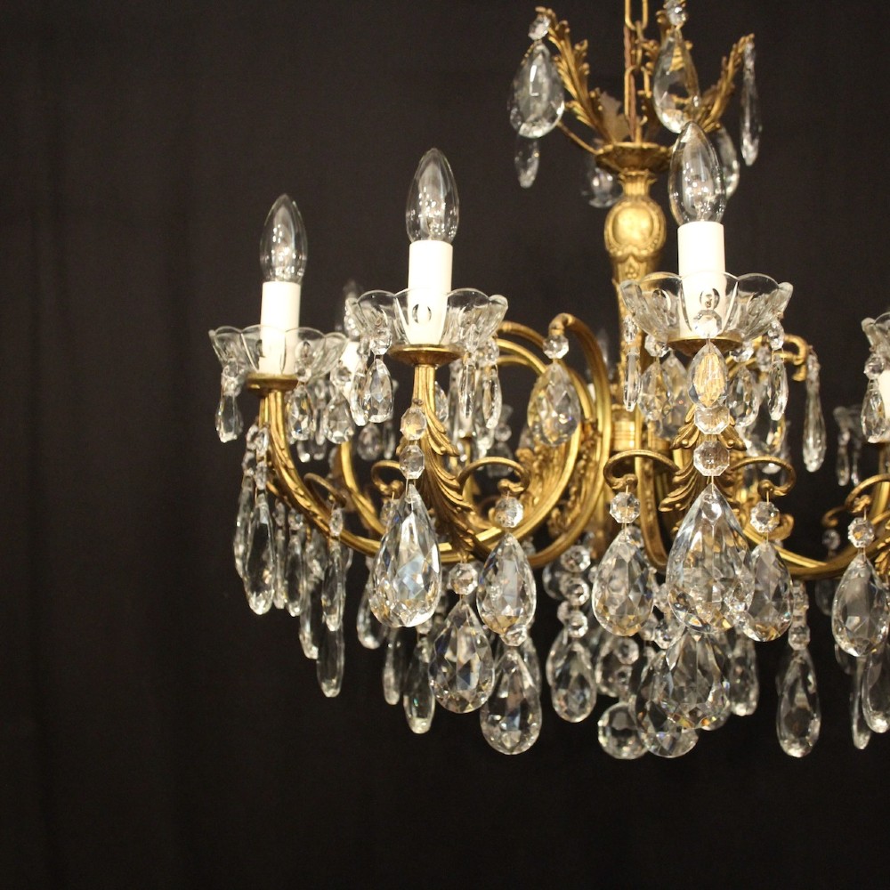A French gilded brass twelve-light chandelier hung with faceted crystal droplets and glass bobeches. View IV