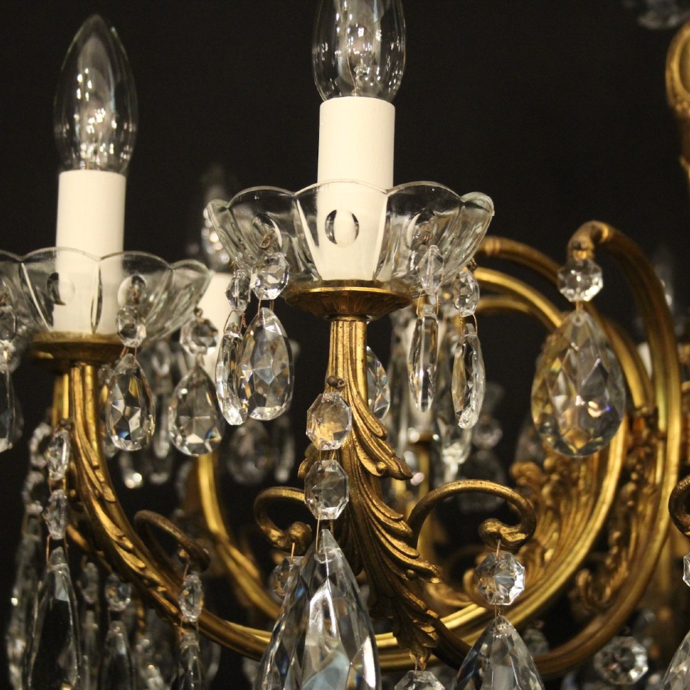 A French gilded brass twelve-light chandelier hung with faceted crystal droplets and glass bobeches. View VI