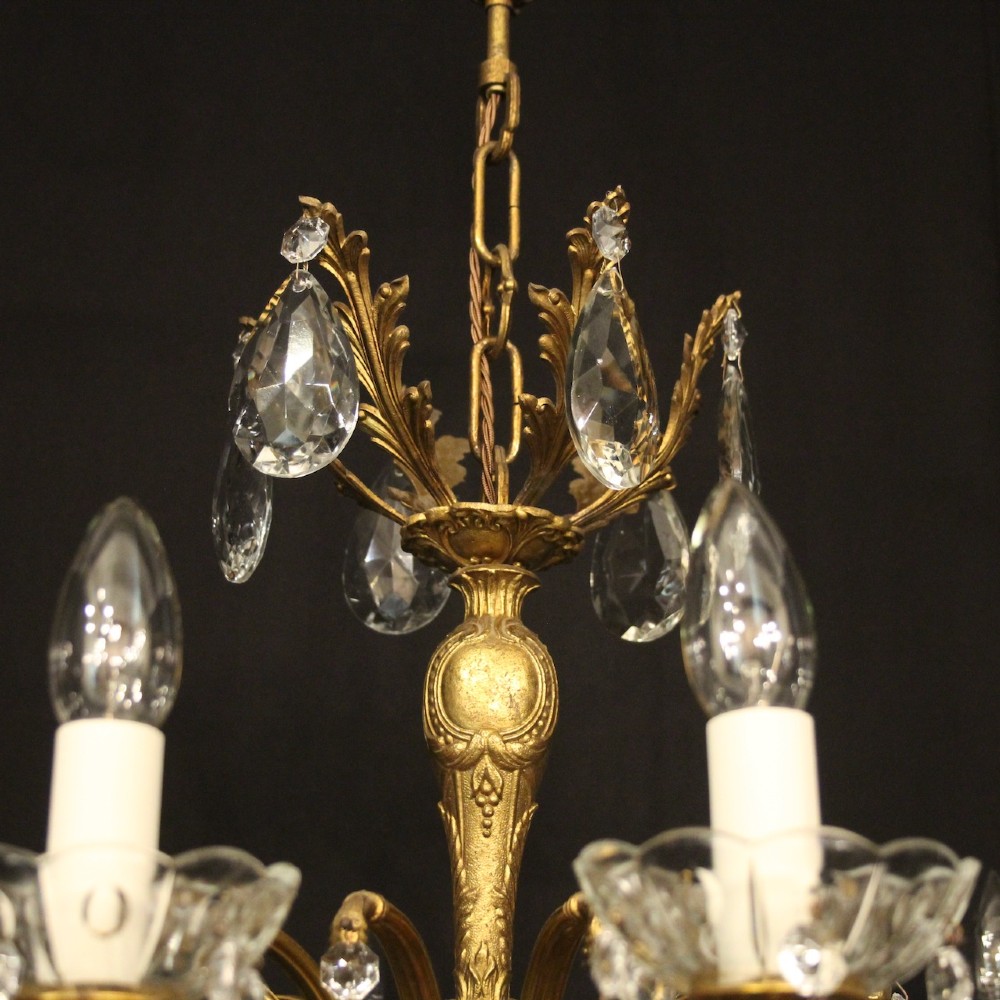 A French gilded brass twelve-light chandelier hung with faceted crystal droplets and glass bobeches. View IX