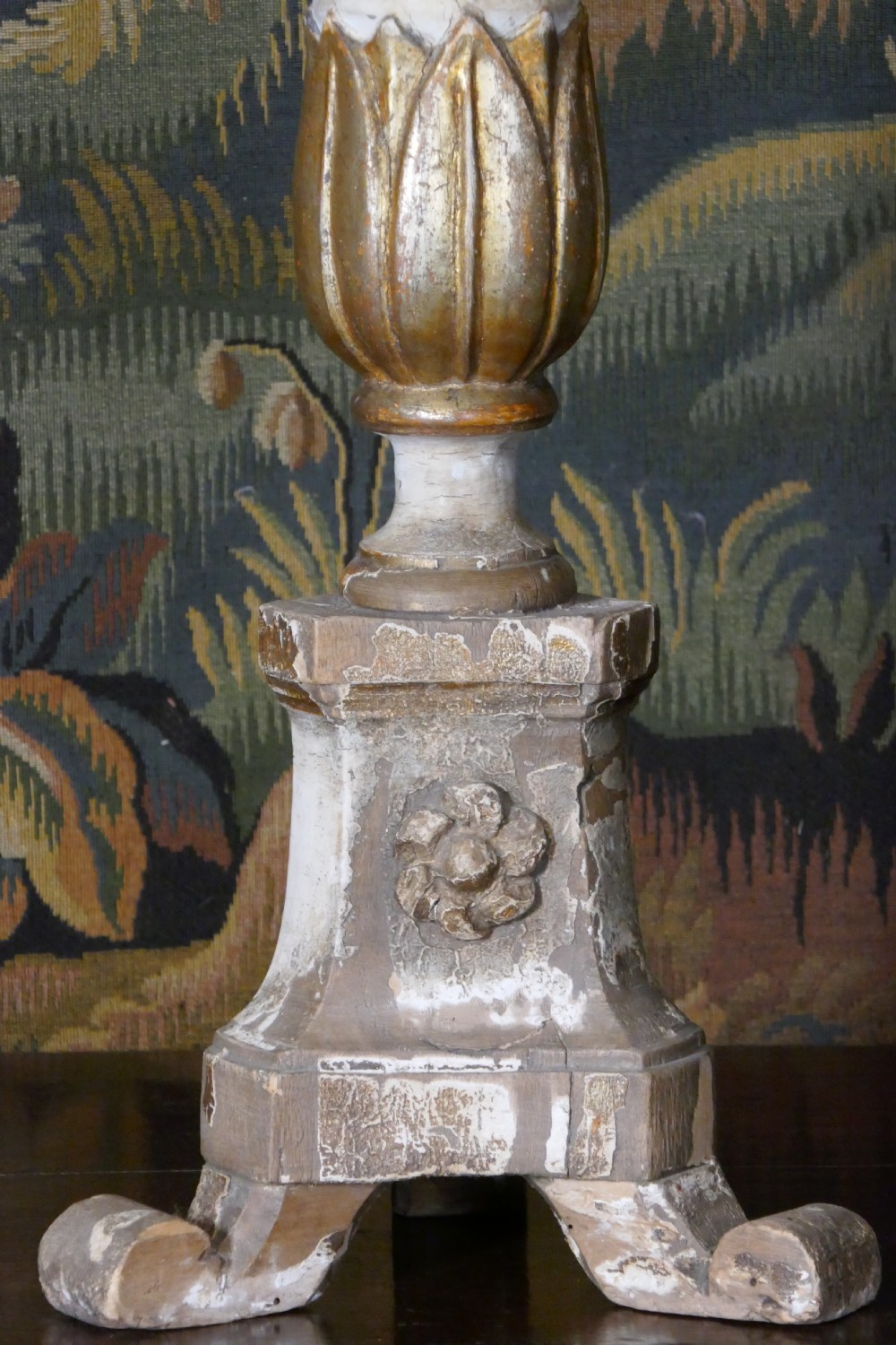 A carved 19th-century wooden pricket candlestick featuring distressed off-white paint, exposed gold leafing, an acanthus column motif, and an iron candle spike. View III