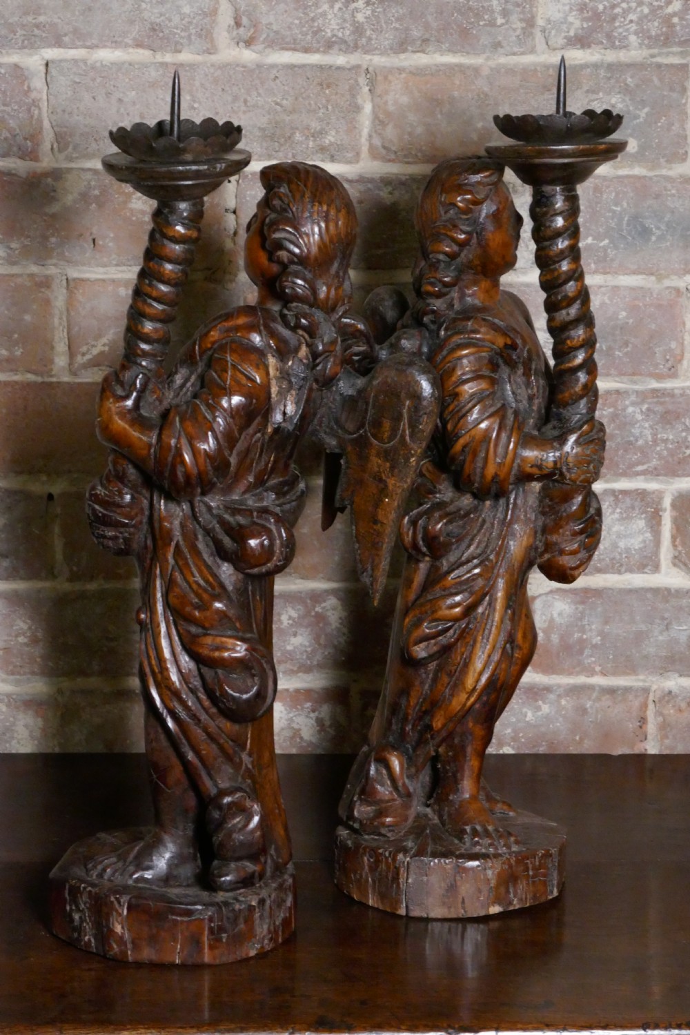 A pair of antique hand-carved wooden candlesticks depicting standing winged angels holding barley-twist pricket stands. View IV