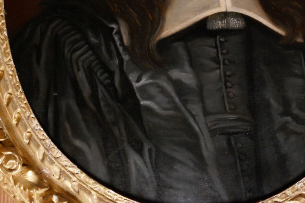 An antique oval oil painting depicting a gentleman in dark clothing and a white collar, framed in an ornate gilded carved frame. View V