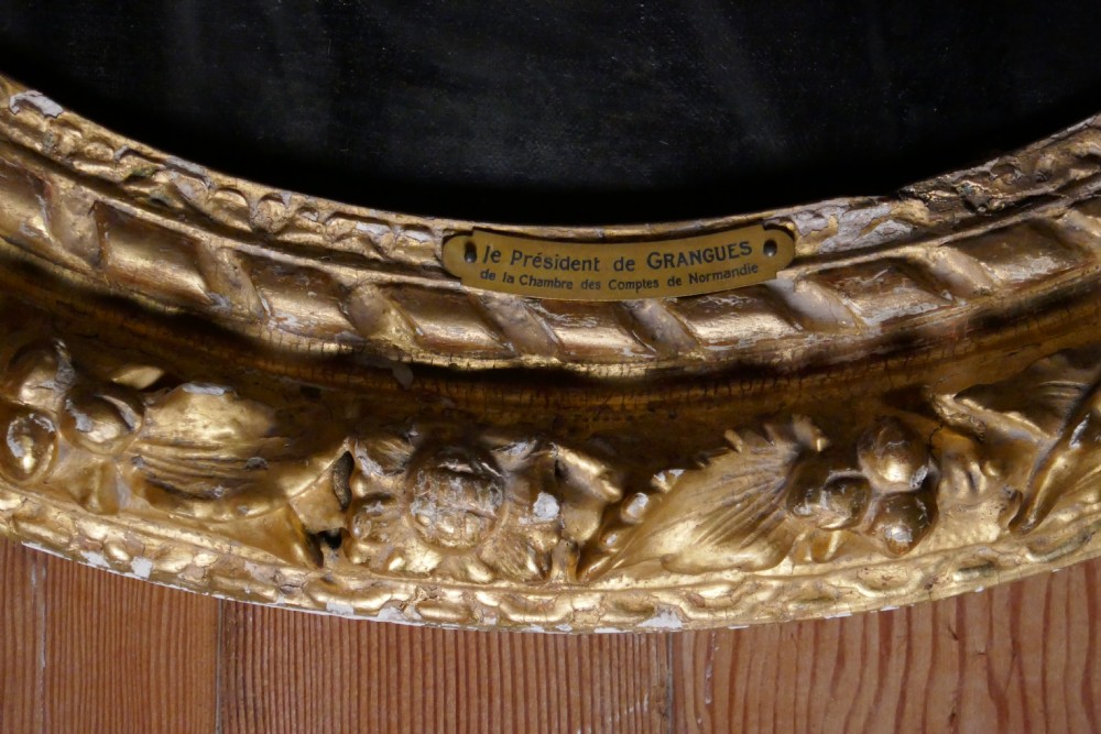 An antique oval oil painting depicting a gentleman in dark clothing and a white collar, framed in an ornate gilded carved frame. View VI