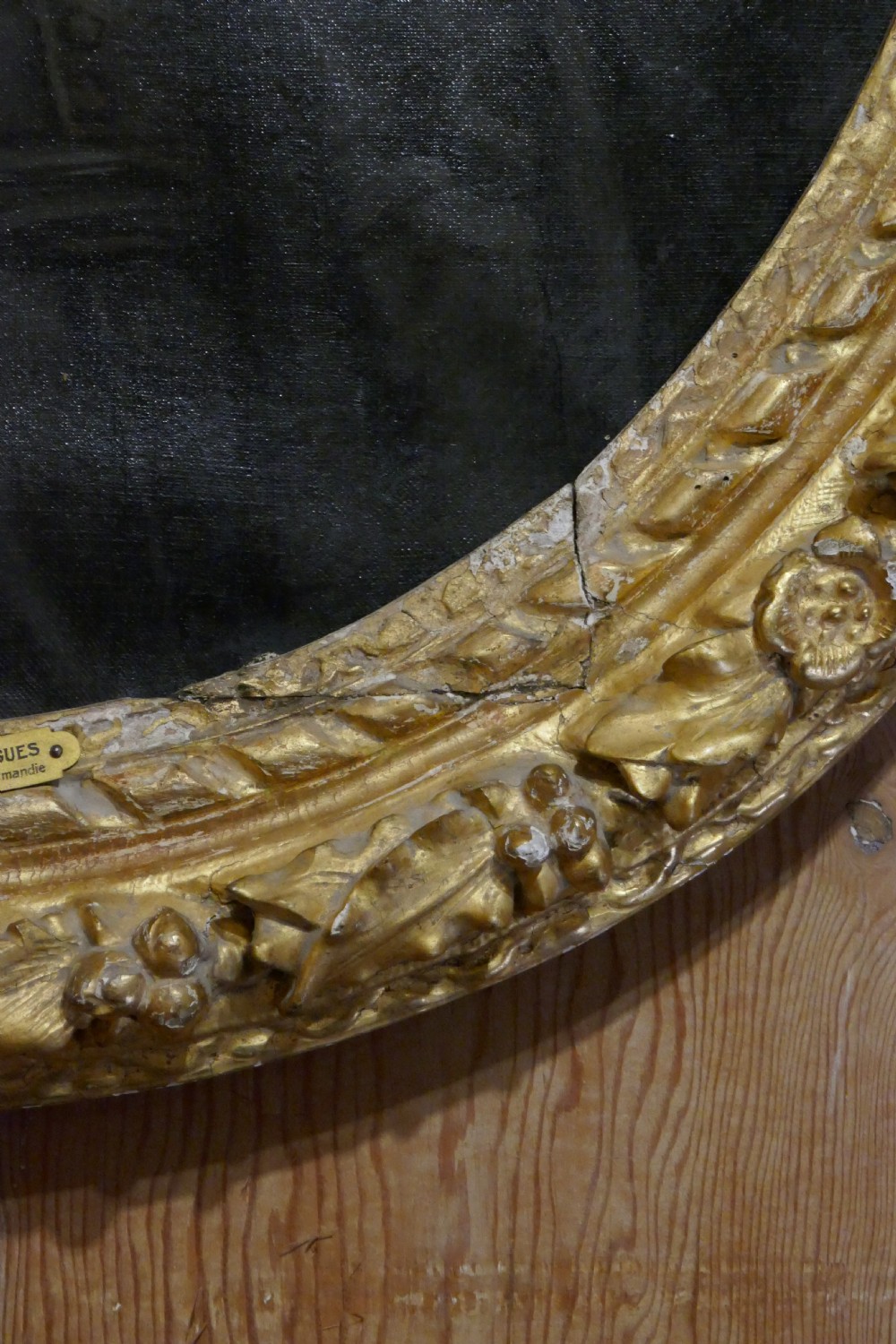 An antique oval oil painting depicting a gentleman in dark clothing and a white collar, framed in an ornate gilded carved frame. View VII