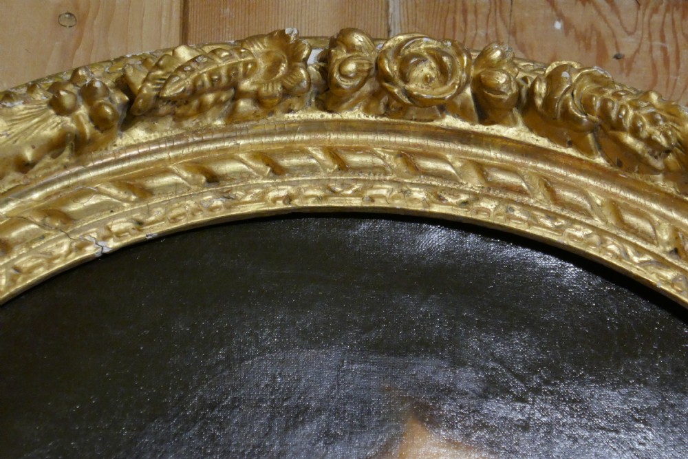 An antique oval oil painting depicting a gentleman in dark clothing and a white collar, framed in an ornate gilded carved frame. View VIII