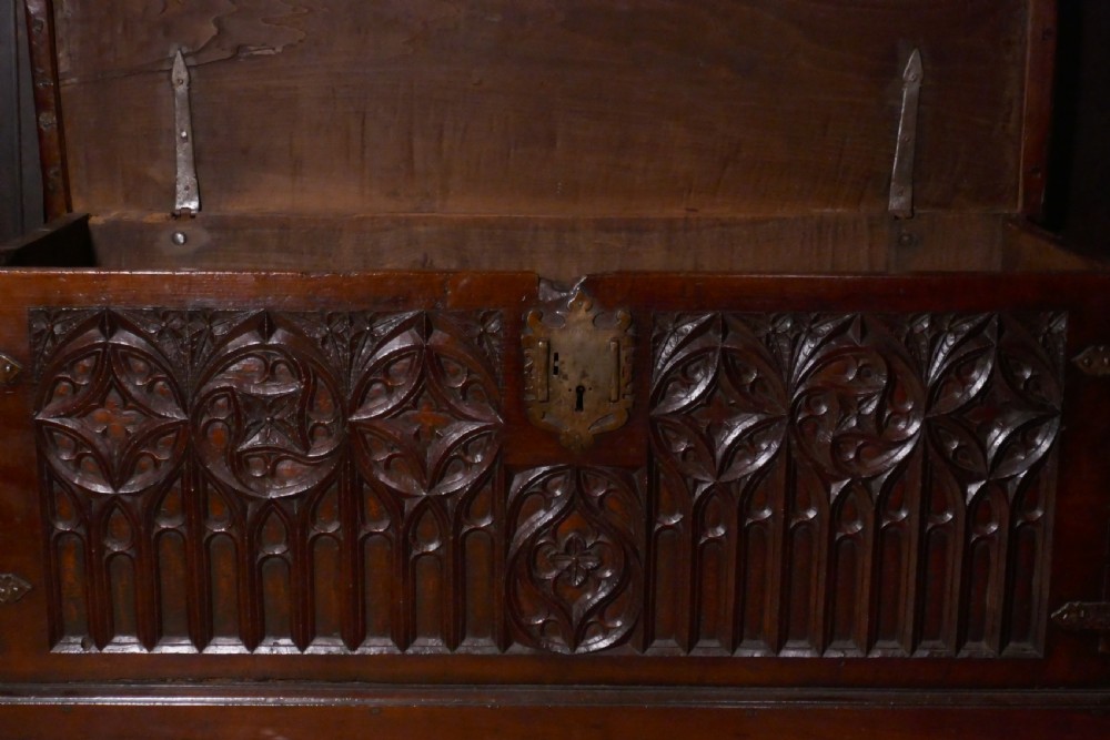 A dark oak 16th-century coffer featuring carved Gothic tracery panels and a central iron lock mechanism. View II