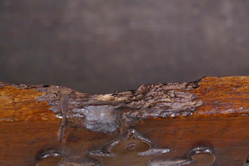 A dark oak 16th-century coffer featuring carved Gothic tracery panels and a central iron lock mechanism. View VI