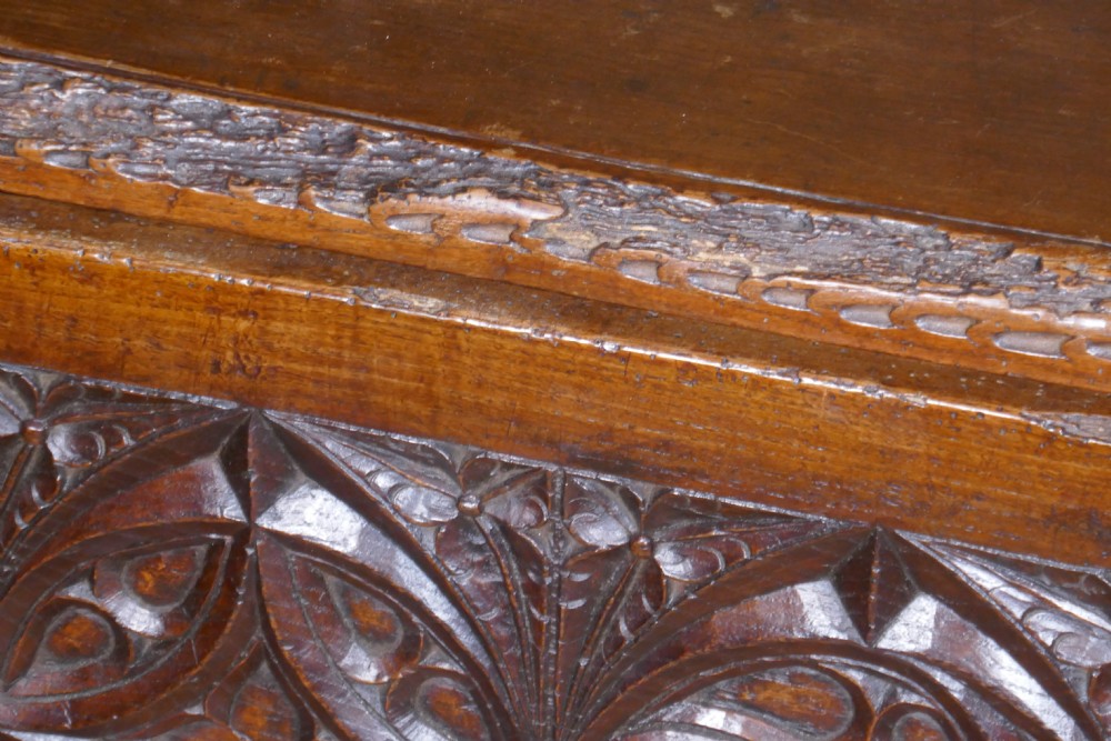 A dark oak 16th-century coffer featuring carved Gothic tracery panels and a central iron lock mechanism. View XIII