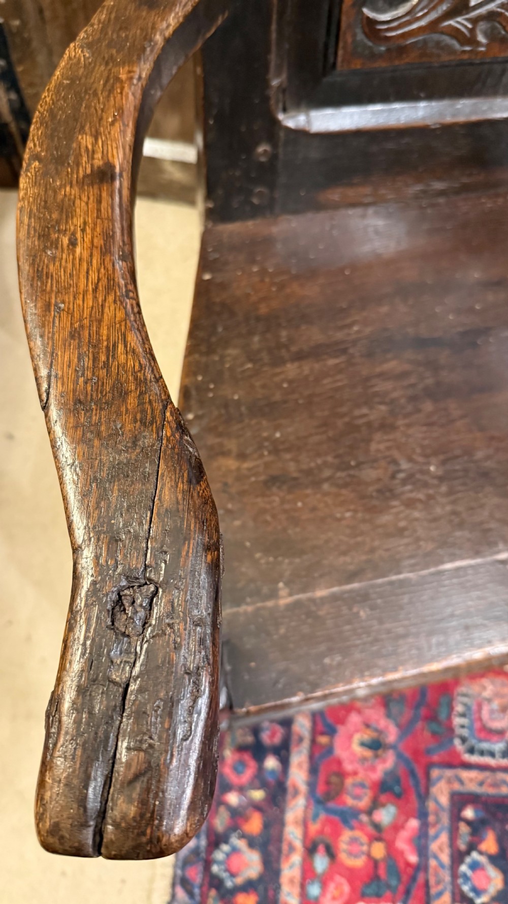 A 17th-century dark oak wainscot armchair with a carved thistle back panel, carved top crest, and turned legs. View XII