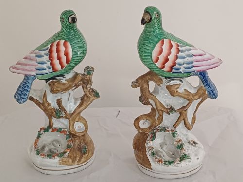 reserved ad a rare pair of staffordshire figures of a bird possibly a pigeon or dove seated on a tree with a nest of eggs below each one is brightly painted and dating circa 1860 - CATEGORY: ANTIQUE CERAMICS - DATED 1860