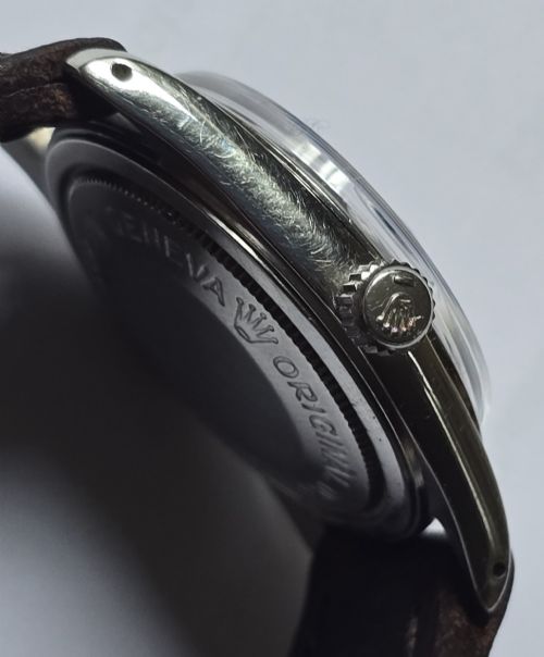 fig 7. A vintage Tudor Prince Oysterdate wristwatch with a stainless steel case, a black dial featuring baton hour markers, a date aperture at three oclock, and a dark brown leather strap.