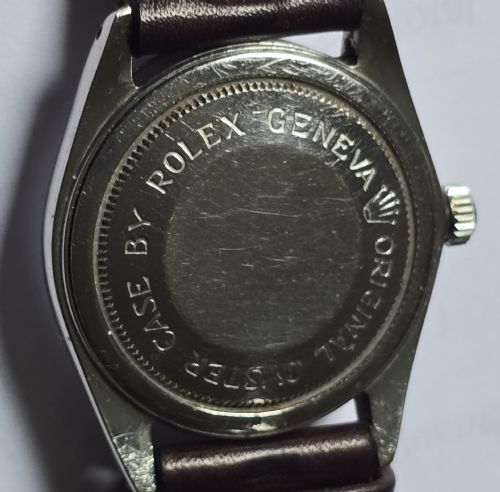 fig 8. A vintage Tudor Prince Oysterdate wristwatch with a stainless steel case, a black dial featuring baton hour markers, a date aperture at three oclock, and a dark brown leather strap.