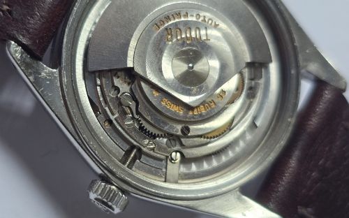 fig 10. A vintage Tudor Prince Oysterdate wristwatch with a stainless steel case, a black dial featuring baton hour markers, a date aperture at three oclock, and a dark brown leather strap.