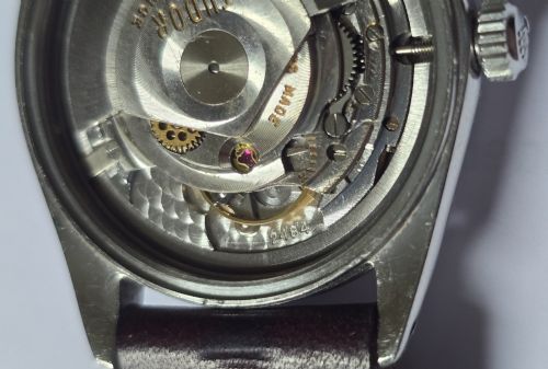 fig 12. A vintage Tudor Prince Oysterdate wristwatch with a stainless steel case, a black dial featuring baton hour markers, a date aperture at three oclock, and a dark brown leather strap.